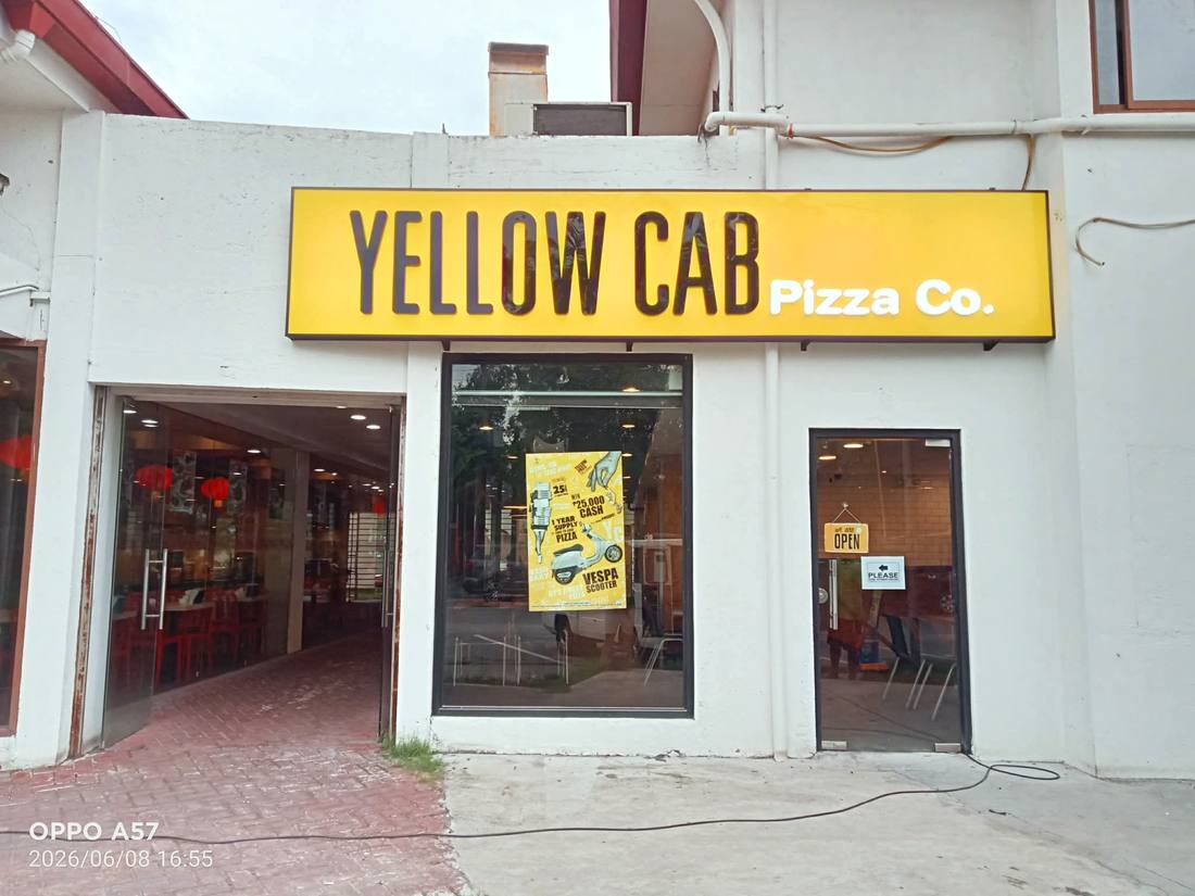 Finished Yellow Cab storefront sign in daylight